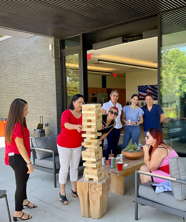 The Oscar Orduno, Inc. office team enjoying a corporate social event and team-building activities on a modern outdoor patio.