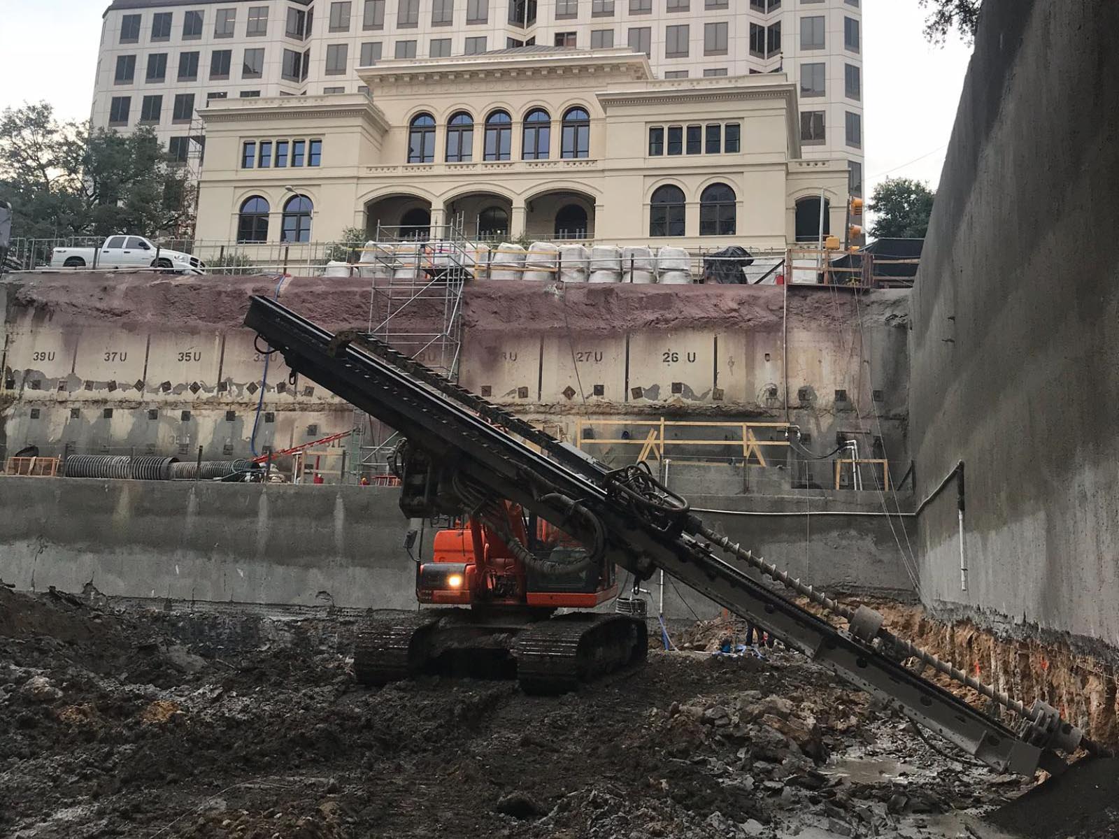 Oscar Orduno, Inc. specialized drilling equipment performing horizontal anchor installation and wall stabilization adjacent to a historic building for Indeed Tower in Austin, Texas.