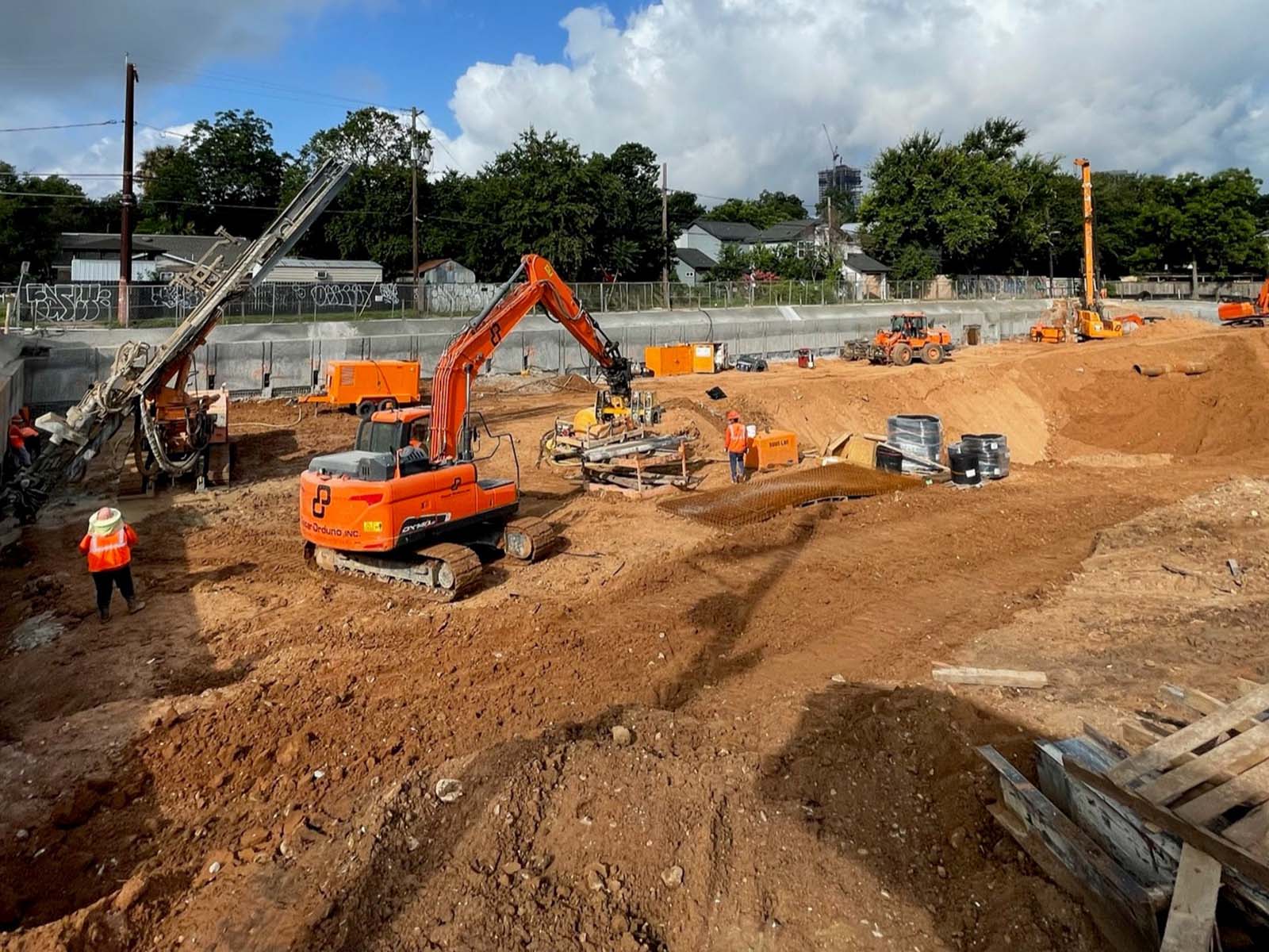 Specialized drilling rig and excavators from Oscar Orduno, Inc. installing Anchor Soldier Pile System and Tieback Anchors near Cesar Chavez in Austin, Texas.