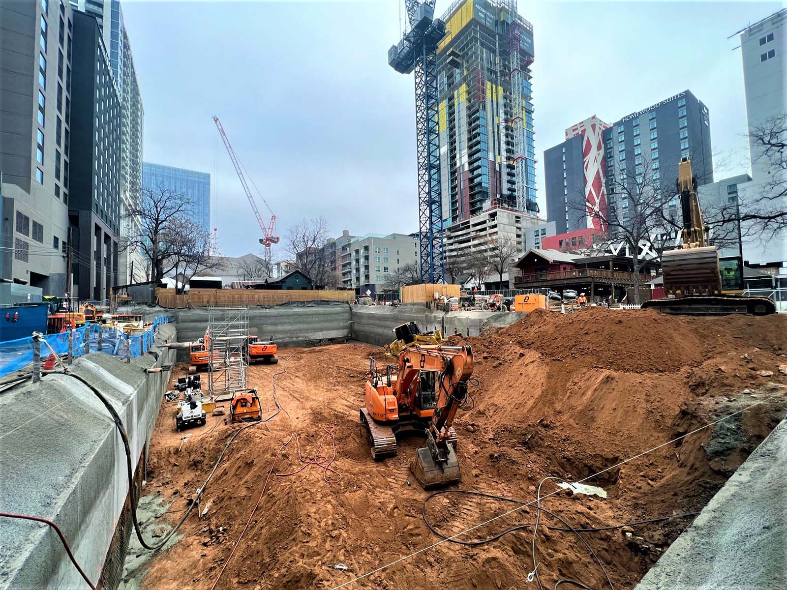 Deep excavation at Paseo 80 Rainey in Austin, TX, featuring Anchored Soldier Piles, Tieback Anchors, and Soil Nail Anchors by Oscar Orduno, Inc.