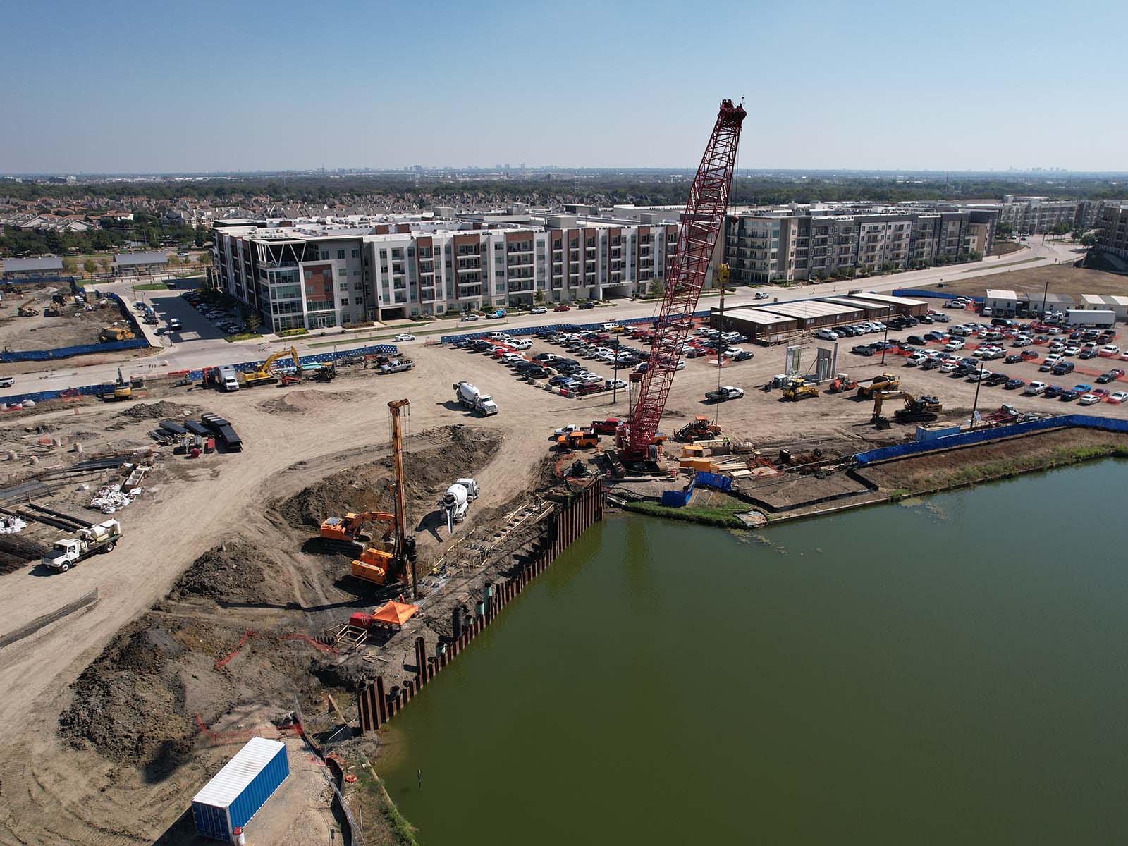 Deep urban excavation featuring soil nail anchors and structural shotcrete walls installed by Oscar Orduno, Inc. to protect adjacent high-rise buildings.