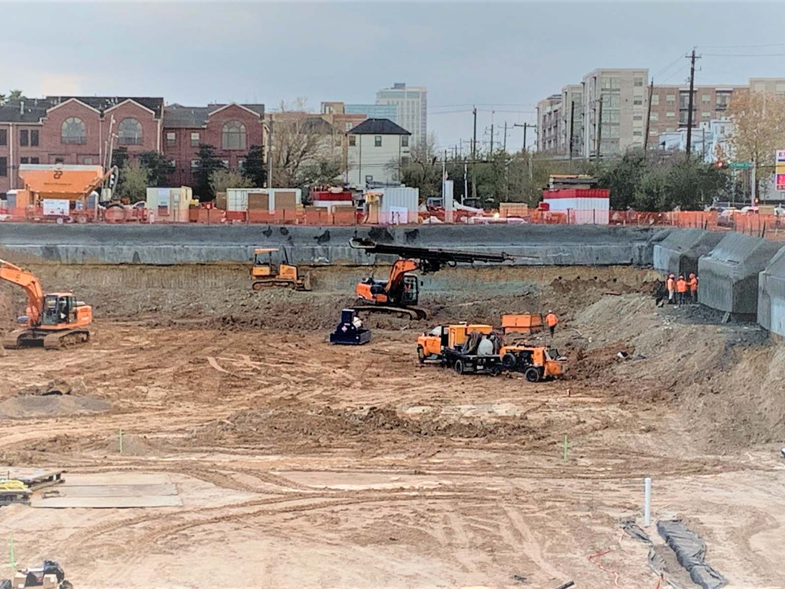 Deep urban excavation featuring specialized drilling equipment and multi-tiered wall stabilization by Oscar Orduno, Inc. for The Ismaili Center in Houston TX.