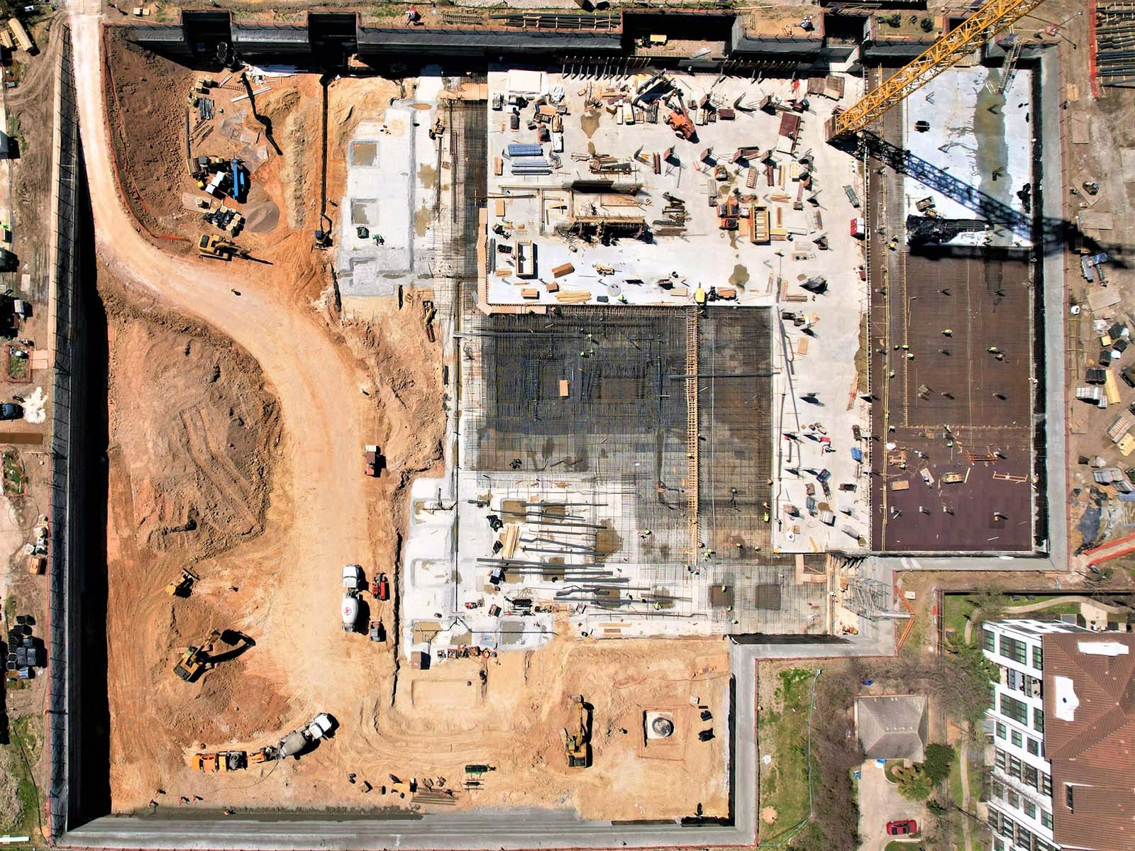 Overhead view of a massive urban excavation featuring foundation reinforcement and perimeter earth retention walls by Oscar Orduno, Inc. for The Ismaili Center in Houston TX