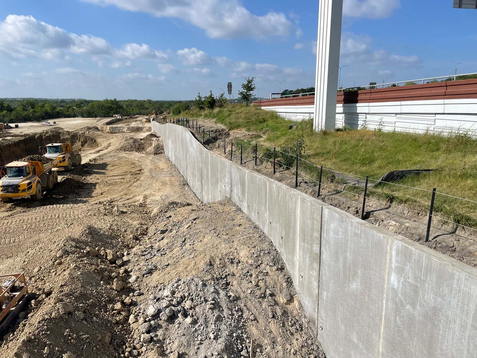 Completed permanent drilled shaft retaining wall for highway slope stabilization in Austin, Texas, by Oscar Orduno, Inc.