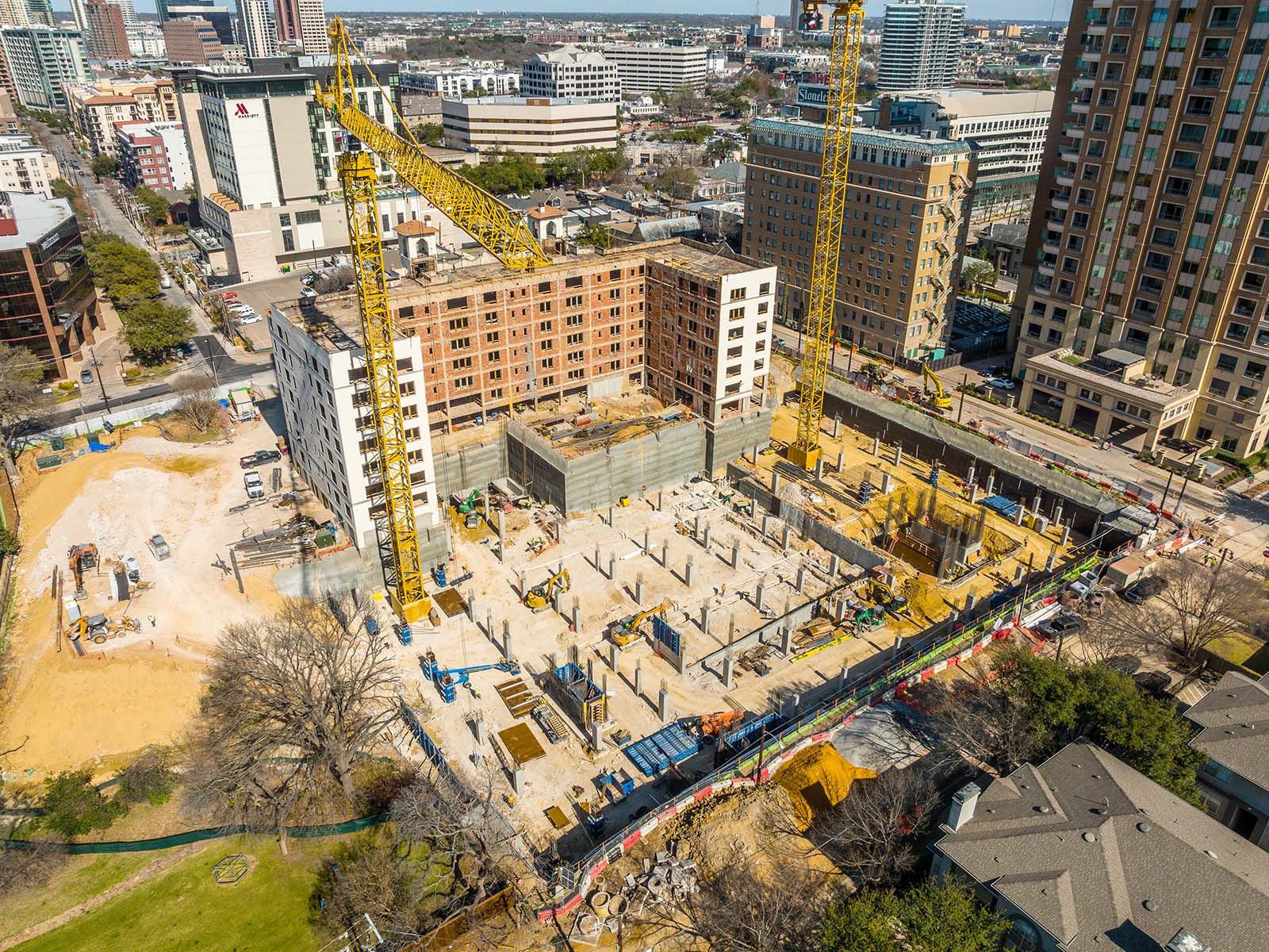Aerial view of a major metropolitan construction site featuring heavy cranes and specialized foundation equipment from Oscar Orduno, Inc.