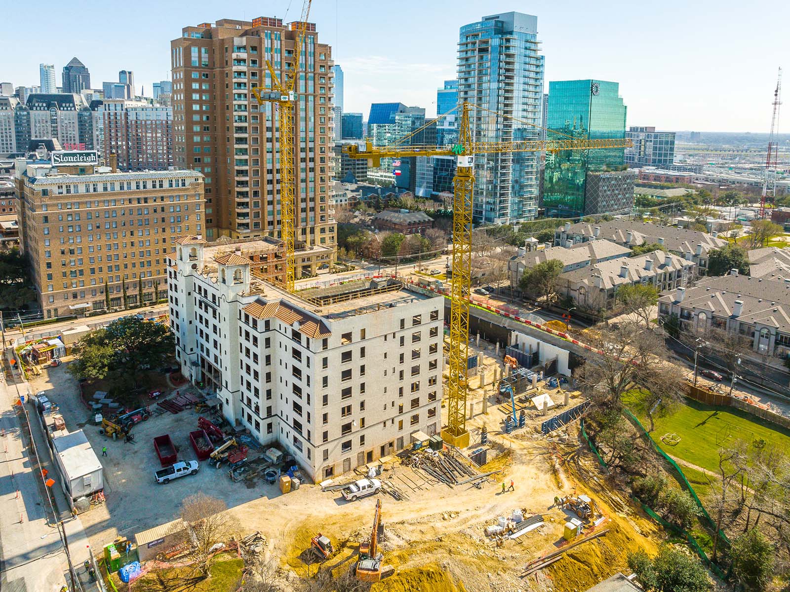 Aerial view of a major metropolitan construction site featuring heavy cranes and specialized foundation equipment from Oscar Orduno, Inc.