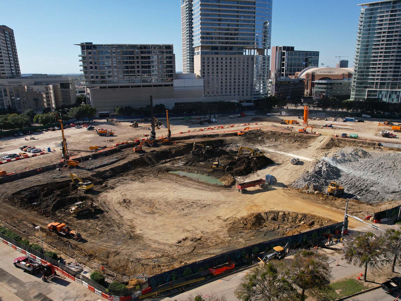 Oscar Orduno, Inc. utilizing specialized orange drilling rigs and crawler excavators for high-torque drilled shaft wall installation.