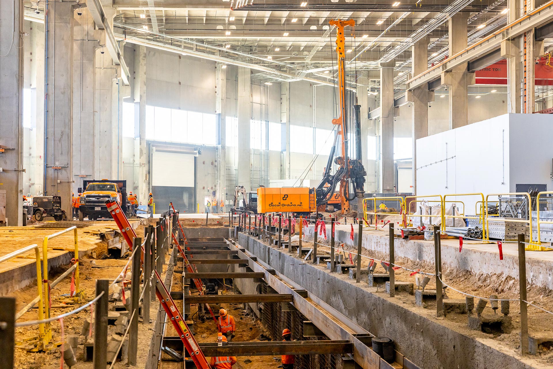 Oscar Orduno, Inc. utilizing specialized low-profile drilling rigs and internal bracing for a specialty foundation project inside an industrial facility.